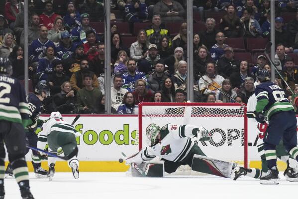 Minnesota Wild goalie Filip Gustavsson (32), of Sweden, stops Vancouver Canucks' Ilya Mikheyev (65), of Russia, during the third period of an NHL hockey game in Vancouver, British Columbia, on Saturday, Dec. 10, 2022. (Darryl Dyck/The Canadian Press via AP)