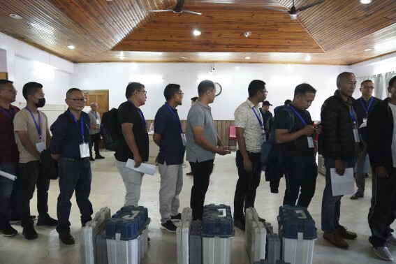 Polling officers stand in a queue to collect electronic voting machines and other election material on the eve of the first round of voting in the six-week long national election in Kohima, capital of the northeastern Indian state of Nagaland, Thursday, April 18, 2024. (AP Photo/Yirmiyan Arthur)