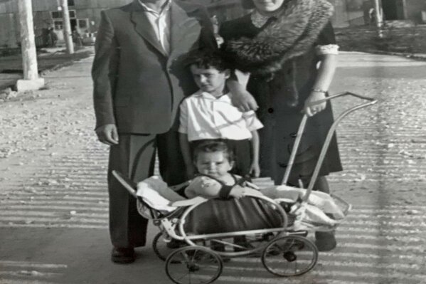In this photo provided by Israel Eisenberg, Israel "Sasha" Eisenberg, center, is photographed with his parents and younger brother Moty at the Hallein Displaced Persons Camp in Austria in 1947 after World War II. Eisenberg recently became reunited, after more than 70 years, with fellow Holocaust survivor Ruth Brandspiegel, whom he met at the displaced camp in Austria where they became friends. (Courtesy of Israel Eisenberg via AP)