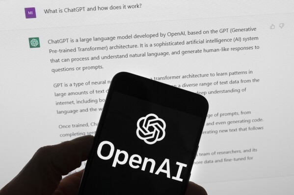 FILE - The OpenAI logo is seen on a mobile phone in front of a computer screen which displays output from ChatGPT, Tuesday, March 21, 2023, in Boston. British Prime Minister Rishi Sunak will host a two-day summit focused on frontier AI. It's reportedly expected to be draw a group of about 100 officials from 28 countries, including U.S. Vice President Kamala Harris and executives from key U.S. artificial intelligence companies including OpenAI, Google's DeepMind and Anthropic. (APPhoto/Michael Dwyer, File)