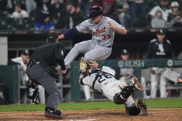 Detroit Tigers designated hitter Colt Keith (33) jumps over Chicago White Sox catcher Korey Lee (26) but is tagged out at home during the eighth inning of a baseball game Wednesday, June 4, 2025, in Chicago. (AP Photo/Erin Hooley)
