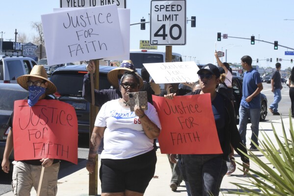 Priscilla Jeffers, center, walks down Palmdale Road during a protest in Victorville, Calif., on Sunday, Sept. 24, 2023. The protest was in response to a viral video showing what appears to be a Southern California sheriff's deputy slamming a teenage girl to the ground during a fight outside a Friday night high school football game, a use of force her mother says sent the 16-year-old to the hospital with injuries to her head and spine. (Jose Quintero/Daily Press via AP)