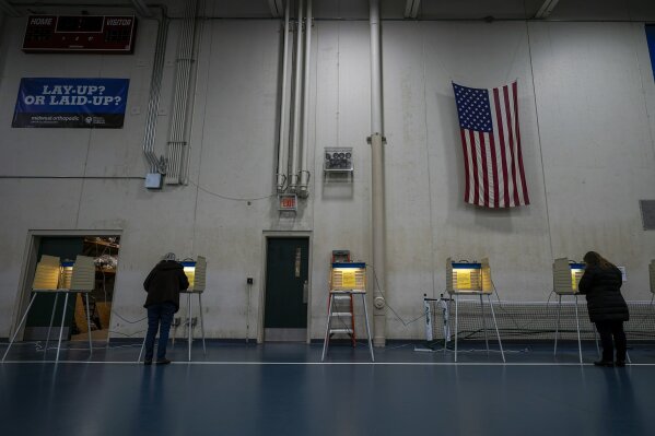 FILE- In this Nov. 3, 2020, file photo people vote at the Milwaukee County Sports Complex in Franklin, Wis. The Wisconsin Supreme Court sided with Democrats on Friday, April 9, 2020, and ruled that the state elections commission should not remove from the rolls voters flagged as possibly having moved, something conservatives have wanted done for nearly two years. (AP Photo/Morry Gash)