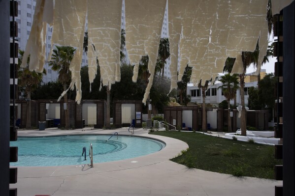 A tattered fabric hangs from a cabana at the shuttered pool area in the Tropicana hotel-casino Friday, March 29, 2024, in Las Vegas. The casino, which is closing April 2, will be demolished to make room for a proposed baseball stadium. (AP Photo/John Locher)