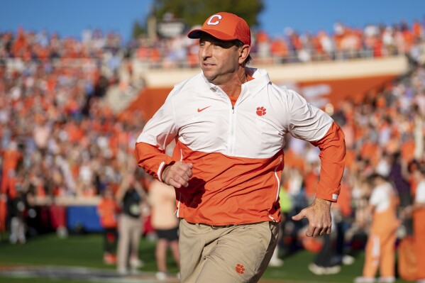 FILE - Clemson head coach Dabo Swinney runs onto the field before an NCAA college football game against North Carolina Saturday, Nov. 18, 2023, in Clemson, S.C. Clemson tries to end its worst season since 2010 with a five-game winning streak when it plays Kentucky in the Gator Bowl.(AP Photo/Jacob Kupferman,File)