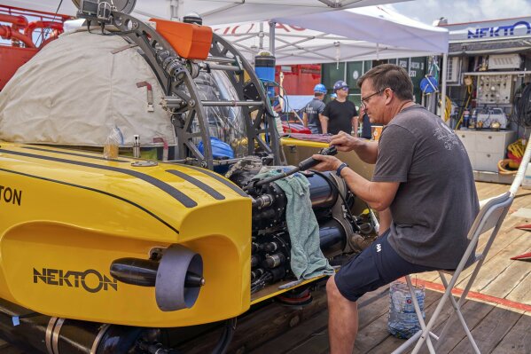 
              A technician conducts maintenance on a submersible as the Ocean Zephyr, the mother-ship of the British-based Nekton mission, sails towards a research dive site in the Seychelles, Wednesday March 6, 2019. The Nekton mission will explore the Indian Ocean, during which researchers hope to document changes taking place beneath the waves that could affect billions of people in the surrounding region over the coming decades. (AP Photo/David Keyton)
            