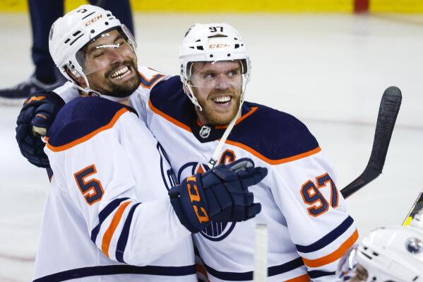 Edmonton Oilers center Connor McDavid, right, celebrates his goal against the Calgary Flames with defenseman Cody Ceci in overtime in Game 5 of an NHL hockey second-round playoff series Thursday, May 26, 2022, in Calgary, Alberta. (Jeff McIntosh/The Canadian Press via AP)
