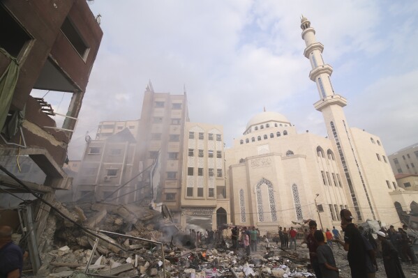 Palestinians inspect the damage of destroyed building after Israeli airstrikes in Khan Younis, Gaza Strip, Tuesday, Oct. 10, 2023. (AP Photo/Hatem Ali)