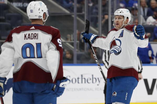 Colorado Avalanche center Nathan MacKinnon, right, celebrates his goal against the New York Islanders during the third period of an NHL hockey game with teammate Nazem Kadri (91) on Monday, March 7, 2022, in Elmont, N.Y. (AP Photo/Jim McIsaac)