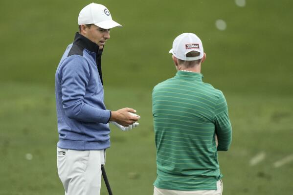 Jordan Spieth, left, works out on the range during a practice for the Masters golf tournament at Augusta National Golf Club, Monday, April 3, 2023, in Augusta, Ga. (AP Photo/Charlie Riedel)