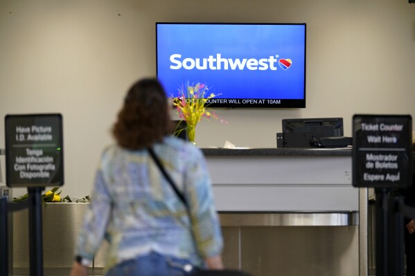 File - A Southwest Airlines passenger arrives to check-in at the Des Moines International Airport, April 18, 2023, in Des Moines, Iowa. A federal judge has set off a debate among legal scholars by ordering lawyers for Southwest Airlines to undergo "religious-liberty training" by a conservative Christian legal group. (AP Photo/Charlie Neibergall, File)