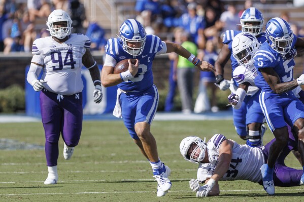 Duke's Riley Leonard, second from left, carries the ball past Northwestern's Xander Mueller (34) and R.J. Pearson (94) during the first half of an NCAA college football game in Durham, N.C., Saturday, Sept. 16, 2023. (AP Photo/Ben McKeown)