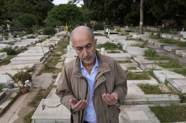 Mohammed Othman, a Palestinian survivor of the April 13, 1975 attack on a bus carrying Palestinians that sparked Lebanon's civil war, prays over the graves of those killed that day, at the Palestine Martyrs Cemetery, in Beirut, Lebanon, Friday, April 11, 2025. (AP Photo/Hussein Malla)