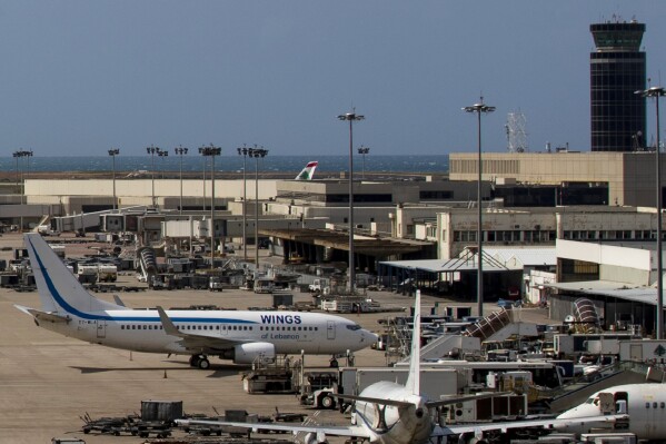 FILE - Planes are grounded due to the coronavirus pandemic at the Rafik Hariri International Airport in Beirut, Lebanon, on March 19, 2020. The information display screens at Beirut’s international airport have been hacked by domestic anti-Hezbollah groups, as clashes between the Lebanese militant group and the Israeli military continue to intensify along the border. Departure and arrival information Sunday was replaced by a message accusing the Hezbollah group of putting Lebanon at risk of an all-out war with Israel. (AP Photo/Hassan Ammar, File)