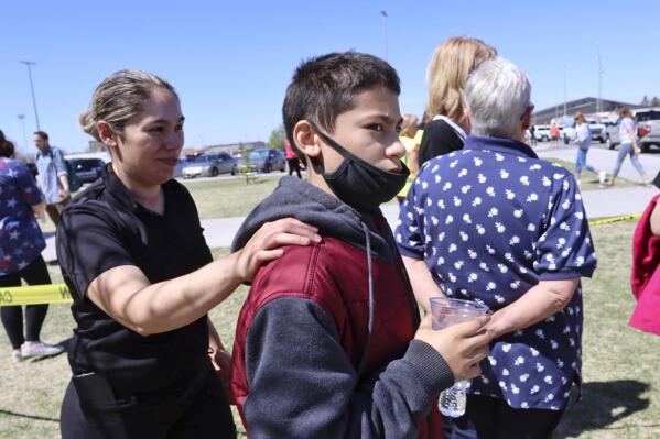 RETRANSMISSION TO CORRECT FIRST NAME TO ADELA  - Adela Rodriguez, left, walks with her son, Yandel Rodriguez, 12, at the high school where people were evacuated after a shooting at the nearby Rigby Middle School earlier Thursday, May 6, 2021, in Rigby, Idaho. Authorities said that two students and a custodian were injured, and a male student has been taken into custody. (AP Photo/Natalie Behring)