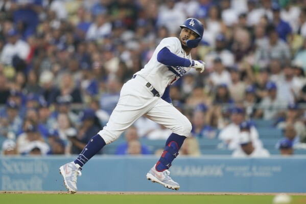 Los Angeles Dodgers' Mookie Betts runs back to first base after hitting a single against the Colorado Rockies during the first inning of a baseball game Friday, Aug. 11, 2023, in Los Angeles. (AP Photo/Ryan Sun)