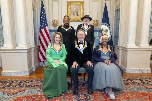 From left, 2023 Kennedy Center Honorees Ren茅e Fleming, Queen Latifah, Billy Crystal, Barry Gibb and Dionne Warwick pose for a photo at the State Department following the Kennedy Center Honors gala dinner, Saturday, Dec. 2, 2023, in Washington. (AP Photo/Kevin Wolf)