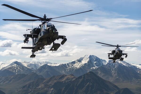 In this photo released by the U.S. Army, AH-64D Apache Longbow attack helicopters from the 1st Attack Battalion, 25th Aviation Regiment, fly over a mountain range near Fort Wainwright, Alaska, on June 3, 2019. The U.S. Army says two Army helicopters similar to the ones in this picture crashed Thursday, April 27, 2023, near Healy, Alaska, killing three soldiers and injuring a fourth. The helicopters were returning from a training flight to Fort Wainwright, based near Fairbanks. (Cameron Roxberry/U.S. Army via AP)