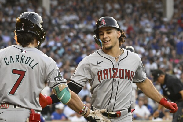 Arizona Diamondbacks outfielder Alek Thomas, right, celebrates with Corbin Carroll (7) after hitting a home run during the fifth inning of a baseball game against the Chicago Cubs, Saturday, July 20, 2024, in Chicago. (AP Photo/Matt Marton)