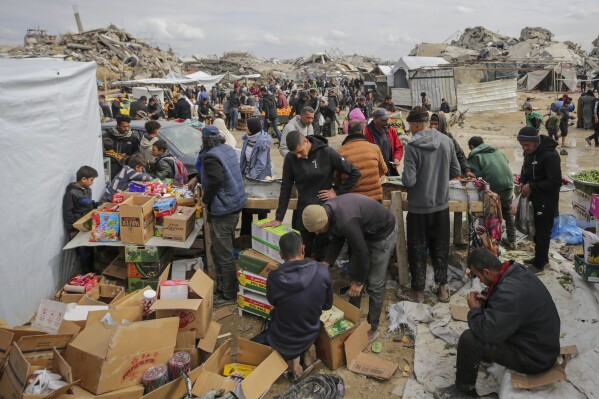 The Palestinians buy goods on a makeshift market installed in the midst of general destruction caused by the refugee camp in Gaza City on Friday, February 7, 2025.