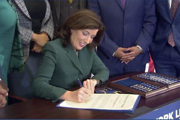 CORRECTS CITY TO NEW YORK - This image from video provided by the Office of The Governor shows New York Gov. Kathy Hochul as she signs a bill in New York, Tuesday, Dec. 19, 2023, to create a commission tasked with considering reparations to address the persistent, harmful effects of slavery in the state. (Office of the Governor via AP)