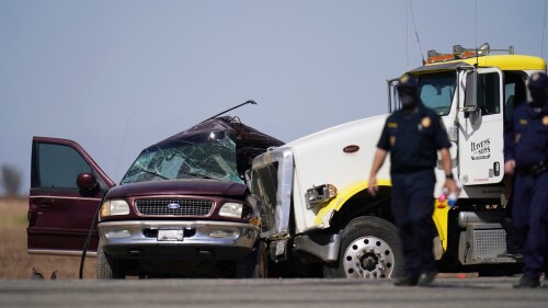 FILE - Law enforcement officers work at the scene of a deadly crash in Holtville, Calif. A federal judge on Thursday, July 13, 2023, sentenced the man who coordinated stashing nearly two dozen migrants into a Ford Expedition that crashed into a tractor-trailer killing 13 people. Jose Cruz Noguez was sentenced to 15 years in prison after pleading guilty earlier this year to charges stemming from the March 2, 2021, crash near the California desert town of Holtville. (AP Photo/Gregory Bull, File)