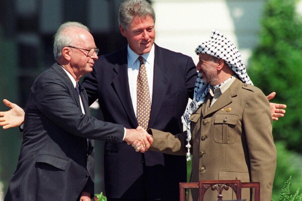 FILE - Israeli Prime Minister Yitzhak Rabin, left, and Palestinian leader Yasser Arafat shake hands marking the signing of the peace accord between Israel and the Palestinians, in Washington, Sept. 13, 1993. Israel's foreign minister told the Norwegian foreign minister Wednesday, Sept. 13, 2023 that Israel rejects “external dictates” on its handling of the Israeli-Palestinian conflict, according to a statement from his office. Foreign Minister Eli Cohen's statement comes on the 30th anniversary of the Oslo Accords, a peace agreement between Israel and Palestinian leaders which many view as the region's last gasp at peace. (AP Photo/Ron Edmonds, File)