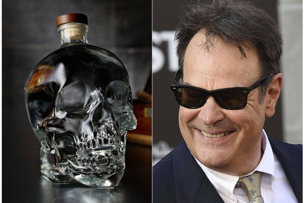 This combination photo shows actor and businessman Dan Aykroyd at the Los Angeles premiere of "Ghostbusters" on July 9, 2016, right, and a bottle of his Crystal Head Vodka. (Crystal Head Vodka via AP, left, and AP Photo)