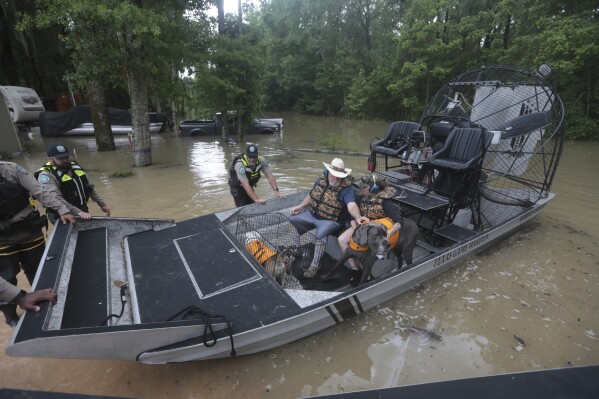 Texas Parks & Wildlife Department game wardens use a boat to rescue residents from floodwaters in Liberty County, Texas, on Saturday, May 4, 2024. (Ǻ Photo/Lekan Oyekanmi)