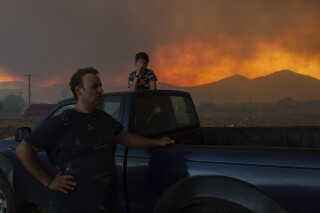 Local residents watch the wildfire in Avantas village, near Alexandroupolis town, in the northeastern Evros region, Greece, Aug. 21, 2023. (AP Photo/Achilleas Chiras)