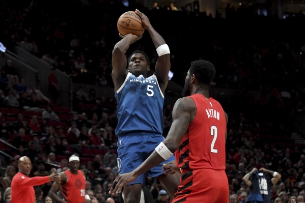 Minnesota Timberwolves guard Anthony Edwards shoots over Portland Trail Blazers center Deandre Ayton during the first half of an NBA basketball game in Portland, Ore., Tuesday Feb. 13, 2024. (AP Photo/Steve Dykes)