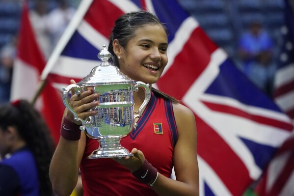 FILE - Emma Raducanu, of Britain, holds up the US Open championship trophy after defeating Leylah Fernandez, of Canada, during the women's singles final of the US Open tennis championships, Saturday, Sept. 11, 2021, in New York. Raducanu beat Diane Parry 4-6, 6-1, 7-6 (1) on Saturday, April 13, 2024, in Le Portel, France, to clinch Britain's berth in the Billie Jean King Cup Finals(AP Photo/Elise Amendola, File)