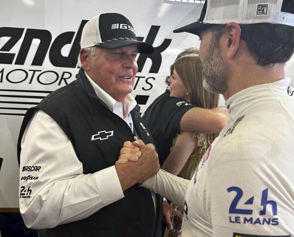 Hendrick Motorsports team owner Rick Hendrick, left, congratulates seven-time NASCAR champion Jimmie Johnson after the Garage 56 car finished the 24 Hours of Le Mans auto race Sunday, June 11, 2023, in Le Mans, France. (AP Photo/Jenna Fryer)