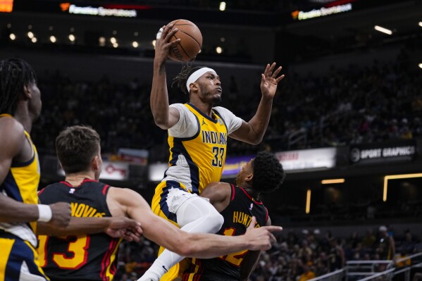 Indiana Pacers center Myles Turner (33) shoots over Atlanta Hawks forward De'Andre Hunter (12) during the second half of an NBA basketball game in Indianapolis, Sunday, April 14, 2024. (AP Photo/Michael Conroy)