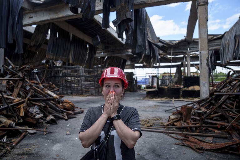 Nina Korsunova is emotional as she walks inside the destroyed Epicenter shopping complex in Kharkiv, Ukraine, Thursday, June 6, 2024. The Russian military's shelling of Epicenter with glide bombs in May killed 19 people, including two children.  In total, gliding bombs hit the city more than 50 times in 2024, according to Spartak Borysenko of the Kharkiv regional prosecutor's office.  (AP Photo/Evgeniy Maloletka)