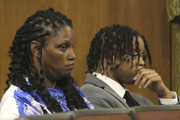 D'Monterrio Gibson, right, and his mother, Sharon McLendon, await the start of the trial of two white men charged in an attack on Gibson, a FedEx employee who was making a delivery, Thursday, Aug. 17, 2023, in Brookhaven, Miss. The judge declared a mistrial of the men who were charged with attempted first-degree murder, conspiracy and shooting into the vehicle driven by Gibson. (Hunter Cloud/The Daily Leader via AP)