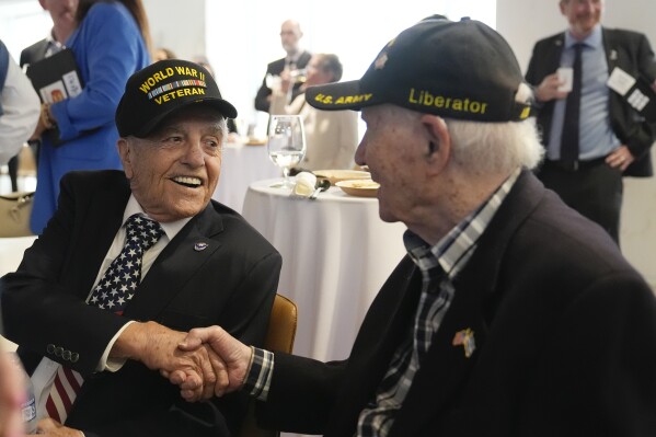 World War II veterans Andy Negra, left, and Hilbert Margol, speak to each other during an an event honoring the two on Thursday, March 14, 2024, in Atlanta. Margol is a 100-year-old World War II veteran living in Dunwoody, Ga. He and his twin brother, Howard Margol, were a part of the 42nd Infantry that arrived in Marseille, France, in January 1945. (AP Photo/Brynn Anderson)