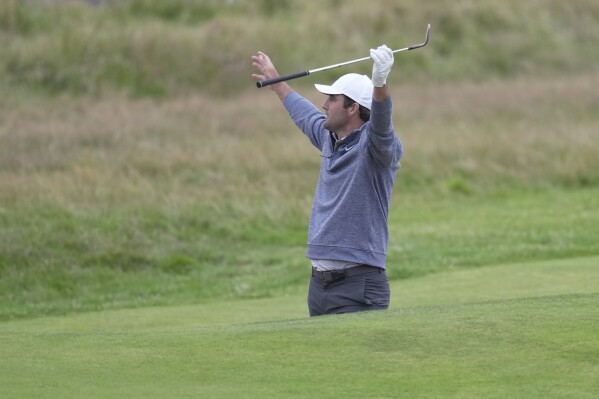 United States' Scottie Scheffler reacts to the crowd aft a bride shot from a bunker on the 18th green during the second day of the British Open Golf Championships at the Royal Liverpool Golf Club in Hoylake, England, Friday, July 21, 2023.(AP Photo/Kin Cheung)