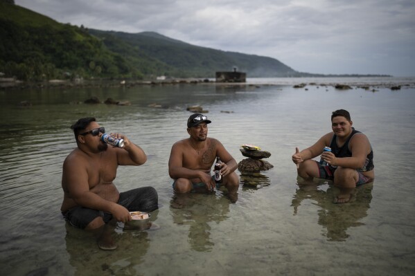 Friends have a drink together after work in Taiarapu-Ouest, Tahiti, French Polynesia, Friday, Jan. 12, 2024. (AP Photo/Daniel Cole)