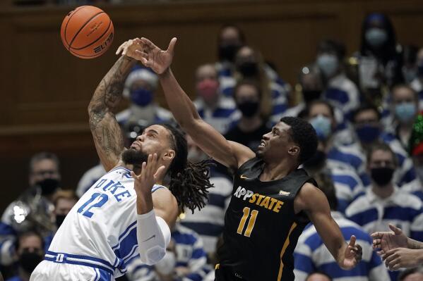 Duke forward Theo John (12) and Appalachian State forward Donovan Gregory (11) reach for the ball during the second half of an NCAA college basketball game in Durham, N.C., Thursday, Dec. 16, 2021. (AP Photo/Gerry Broome)