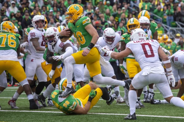 Oregon quarterback Bo Nix (10) scores a touchdown against Washington State during the first half of an NCAA college football game Saturday, Oct. 21, 2023, in Eugene, Ore. (AP Photo/Andy Nelson)