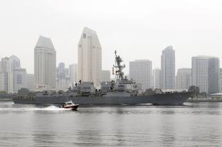 In this April 28, 2020, photo, the USS Kidd passes downtown San Diego as it returns to Naval Base San Diego, seen from Coronado, Calif. Lessons learned from a coronavirus outbreak aboard the aircraft carrier USS Theodore Roosevelt played a central role in limiting damage when the virus hit the USS Kidd at sea (AP Photo/Gregory Bull)