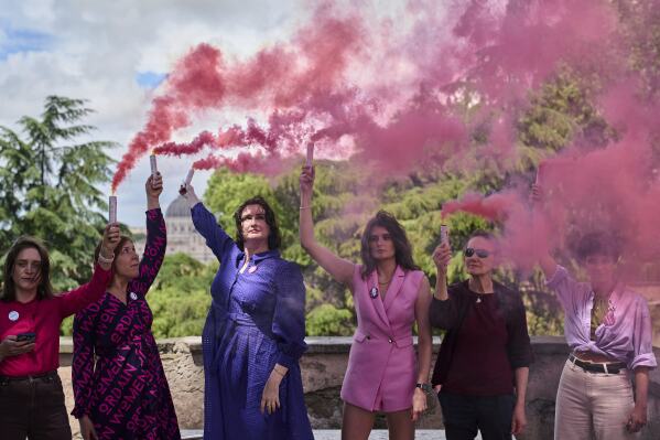 Activists from the Women's Ordination Conference release pink smoke to call for full equality for women in the Catholic Church on the first day of the conclave to elect the 267th pope, in Rome, Wednesday, May 7, 2025. (AP Photo/Bernat Armangue)