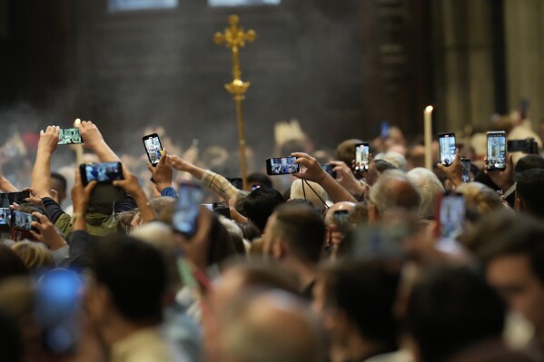 Faithful capture images with their smartphones of cardinals during a final Mass inside St. Peter's Basilica before the conclave to elect a new pope, at the Vatican, Wednesday, May 7, 2025. (AP Photo/Gregorio Borgia)