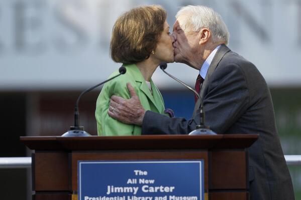 FILE - This Oct. 1, 2009 file photo shows former President Jimmy Carter getting a kiss from his wife Rosalynn as she introduces him during a reopening ceremony for the newly redesigned Carter Presidential Library in Atlanta. Jimmy Carter and his wife Rosalynn celebrate their 75th anniversary this week on Thursday, July 7, 2021. (AP Photo/John Bazemore, File)