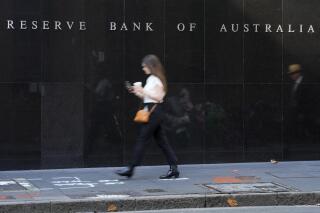 FILE - People walk past the outside of the Reserve Bank in Sydney, Australia on May 3, 2022. Australia’s central bank on Tuesday, July 5, 2022 lifted its benchmark interest rate for a third time in consecutive months, changing the cash rate to 1.35% from 0.85%. (AP Photo/Mark Baker, File)
