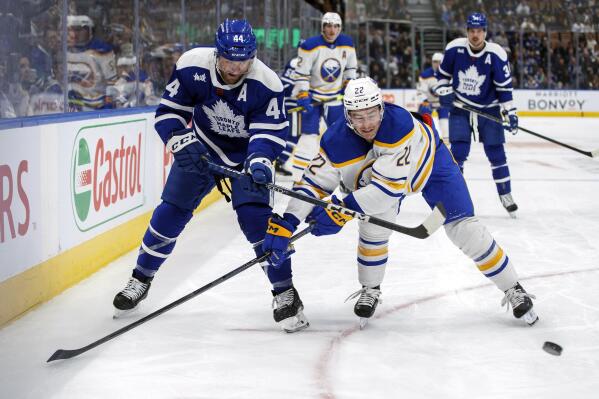 Toronto Maple Leafs' Morgan Rielly (44) and Buffalo Sabres' Jack Quinn (22) vie for the puck during the third period of an NHL hockey game in Toronto on Saturday, Nov. 19, 2022. (Cole Burston/The Canadian Press via AP)