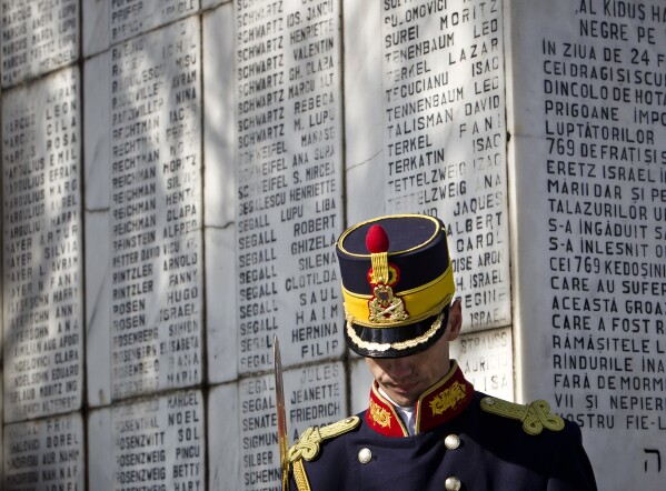 A honor guard soldier stands during a ceremony  at a Jewish cemetery in Bucharest, Romania, Friday, Feb. 24, 2012, next to a monument bearing the names of Jews killed 70 years ago when the SS Struma, the ship they were on as refugees on the way to Palestine, was sunk by a Soviet torpedo in the Black Sea leading to the death of all but one of the 779 people on board. (AP Photo/Vadim Ghirda)