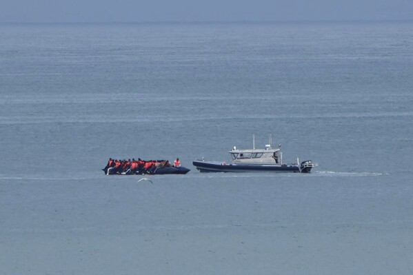 A boat thought to carry migrants is escorted by a vessel from the French Gendarmerie Nationale in the English Channel off Wimereux beach, France, Wednesday, Sept. 4, 2024. (AP Photo/Nicolas Garriga, File)
