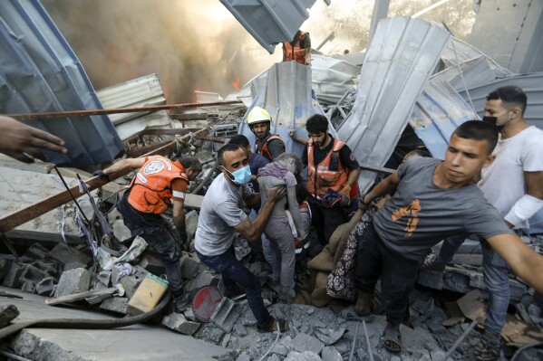 EDS NOTE: GRAPHIC CONTENT - Palestinians carry a dead child that was found under the rubble of a destroyed house following an Israeli airstrike in Gaza City, Saturday, Nov. 4, 2023. (AP Photo/Abed Khaled)